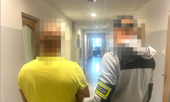 zatrzymany mężczyzna w asyście nieumundurowanego policjanta, który ma na ramieniu opaskę odblaskową z napisem POLICJA