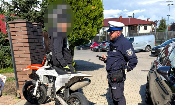 policjant wydziału ruchu drogowego kontrolujący kierującego motocyklem